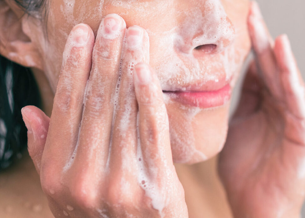 woman washing her face with a cleanser