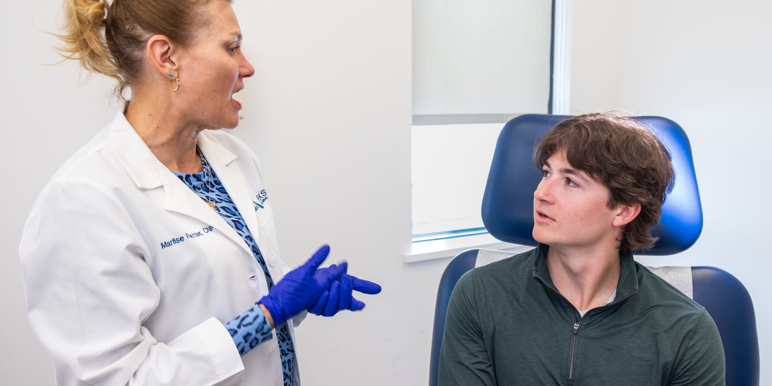 Dermatologist meets with teenage patient to address skin concerns